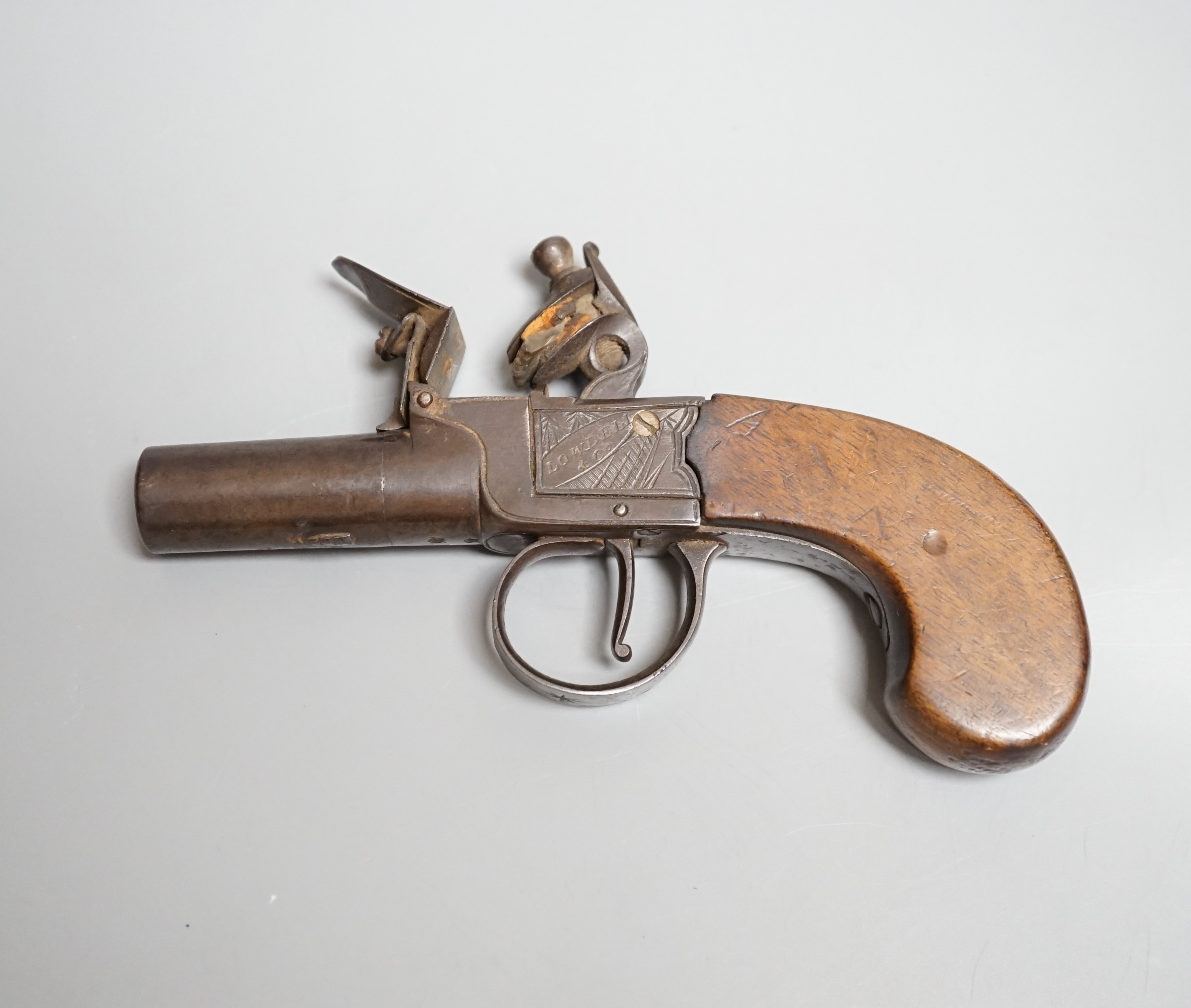 A Flintlock pocket pistol signed Lowdell & Co. Lewes, early 19th century, turn off barrel, signed action engraved with trophies, walnut grip, length 15.5cms